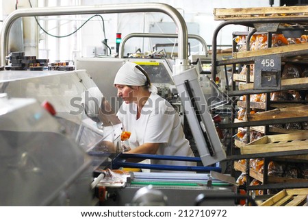 KIEV, UKRAINE - 21 August 2014: An employee of the Kiev packages engine bread bread-baking plant for packing in plastic bags