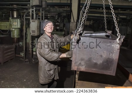 Kharkov, UKRAINE - 7 November 2013: Kharkiv Tractor Plant. in the production of the employee performs his work. Man moves cargo