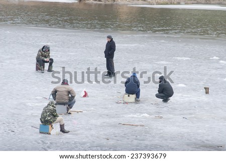 Kiev region, UKRAINE - February 17 2013: A winter fishing on river. People is fishing.