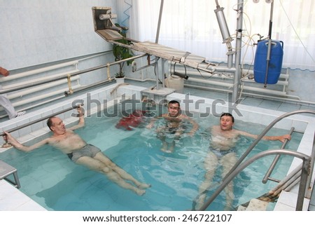 Khmelnik, UKRAINE - 20 May 2011: Group of people, mature man, at water gymnastics or aquarobics