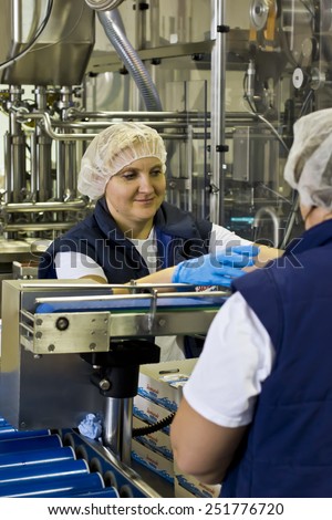 Kiev region, UKRAINE - 15 November 2014: Dairy baby food factory. Worker puts the finished product in boxes