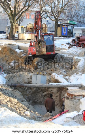 Kiev, UKRAINE - 17 February 2015: The roadway, excavator leads repair work for replacement of water pipes
