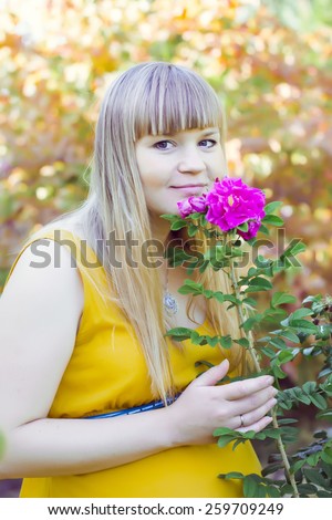 young pregnant girl near of flowers