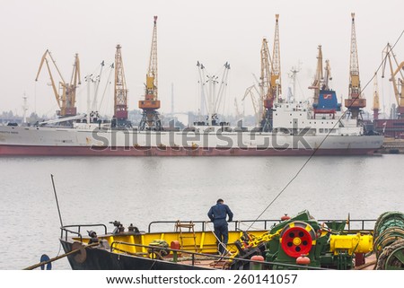 Odessa, Ukraine - October 22, 2011: Sea port of Odessa. A crew member of one of the ships standing on the deck overlooking the port