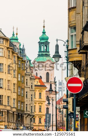 View of old street, green cathedral domes and Zhizhkov Television Tower far away in the center of the Prague, Czech Republic