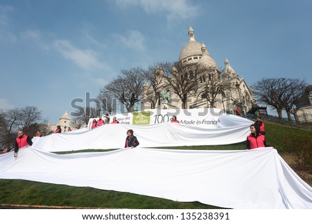 PARIS, FRANCE - APRIL 6: Employees of the company Blanc de Vosges celebrating 170 years of the company posing with the linen 170 meters length 100% Made in France at Montmartre. Paris, April 6, 2013