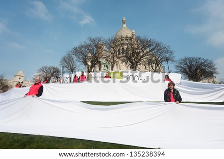 PARIS, FRANCE - APRIL 6: Employees of the company Blanc de Vosges celebrating 170 years of the company posing with the linen 170 meters length 100% Made in France at Montmartre. Paris, April 6, 2013