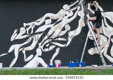 MOSCOW, RUSSIA - 1 JUNE: Lucy Mclauchlan paints the wall on Moscow Ahmad Tea Music Festival. Moscow, 1 June, 2013