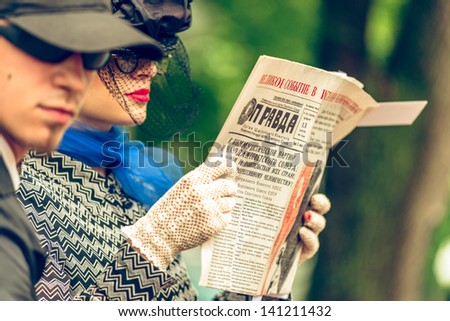 MOSCOW, RUSSIA -  MAY 26: Retro festival \'Days of history\' in Hermitage Garden. Man and woman reading old soviet press. Moscow, May 26, 2013