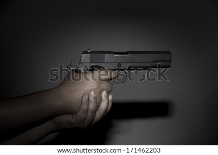 Hand holding gun preparing to fire
