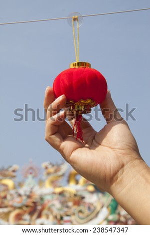 Hand holding red miniature lantern