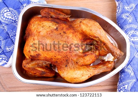 Baked whole marinated chicken in aluminum foil tray