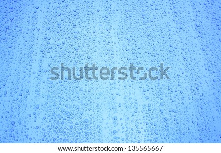 Blue colored water drops on car paint