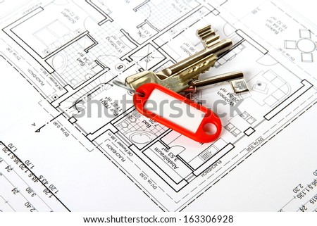 Bunch of keys with red keychains at building drawing, soft focus