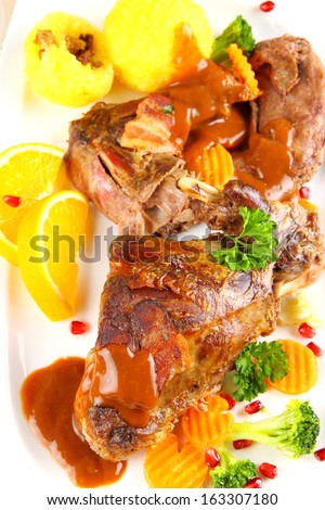 Braised rabbit meat with potato dumplings and vegetables, top view
