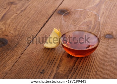 Luxury Cognac in decorative glass on wood with lemon