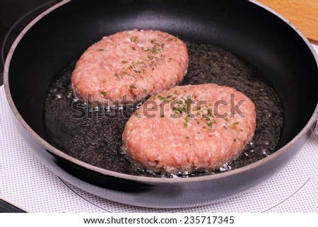 Two hamburger meat in pan in oil fry