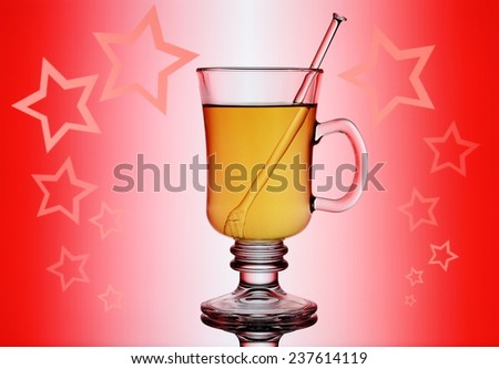 Yellow mulled wine on red background with stars, close up
