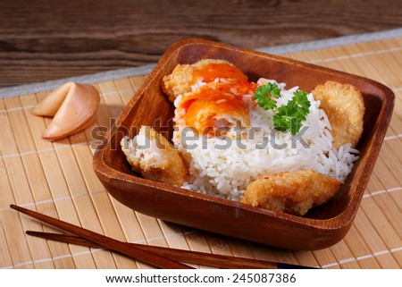 Chicken meat with rice, red sauce on bamboo mat, top view