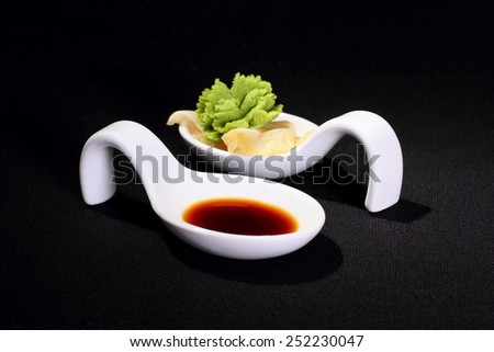 Wasabi and soy sauce on black background, horizontal