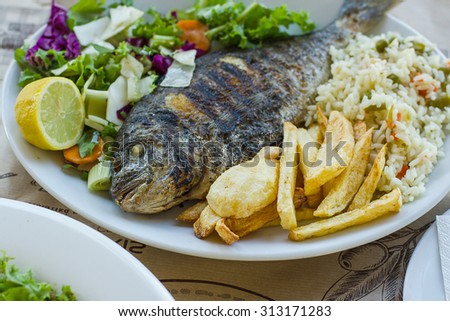 Sea bream with potato, rice and salad, Greek food