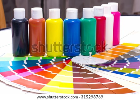 color palette, tubes of paint on white wooden background, close up