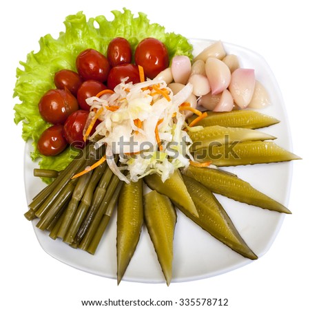 pickles: cucumbers, garlic, leek, tomatoes, cabbage and lettuce leaves in a plate on white background