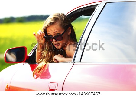 woman in red car get out window