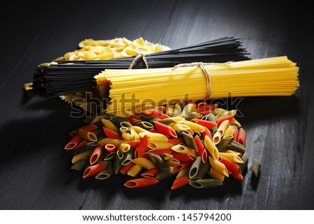 Variety of types and shapes of Italian pasta on black table