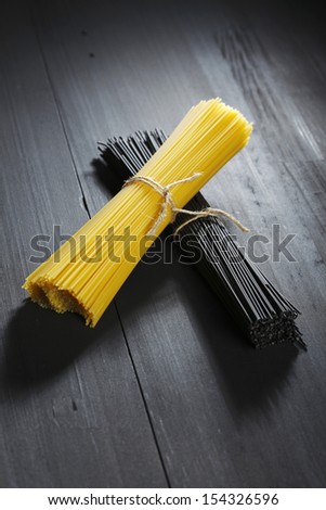 Black and white dry spaghetti on wooden table