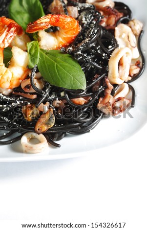 Black spaghetti with seafood isolated on white background