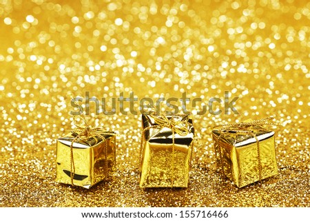 Golden boxes with christmas gifts on shiny glitter background