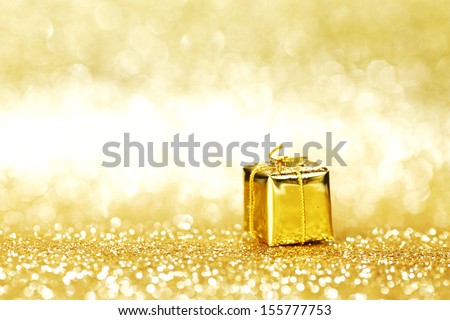 Golden box with christmas gifts on shiny glitter background
