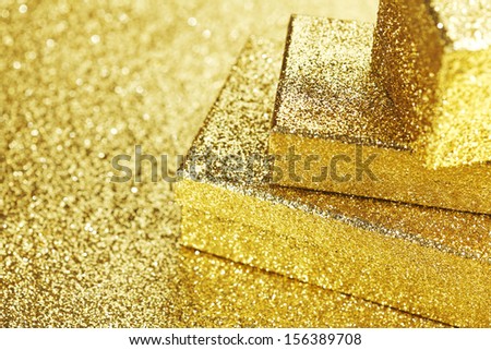 Golden boxes with holiday gifts on shiny glitter background