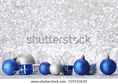 Christmas balls and gifts on silver glitter background