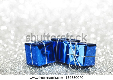 Blue boxes with christmas gifts on shiny silver background