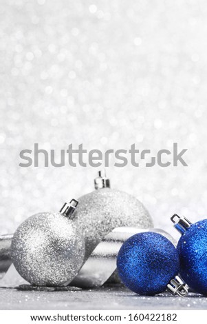 Blue shiny christmas ball on silver glitter background