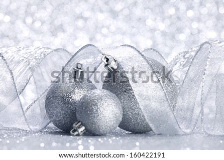 Christmas balls and ribbons decoration on shiny silver background