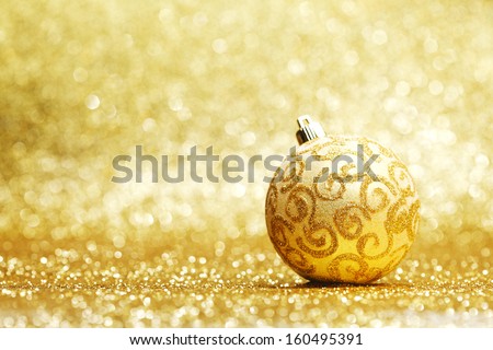 Golden christmas ball on glitter background close-up