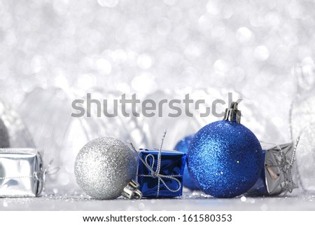 Christmas balls and gifts on silver glitter background