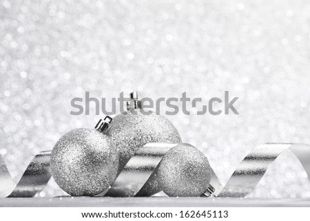 Silver Christmas decoration balls and ribbon on glitter background