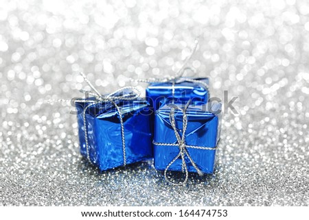 Blue boxes with christmas gifts on shiny silver background
