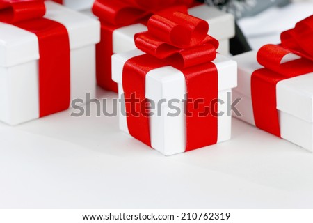 White boxes with gifts decorated with red ribbons on white background
