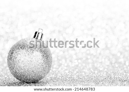 Glittering silver Christmas ball with in shiny glitters background
