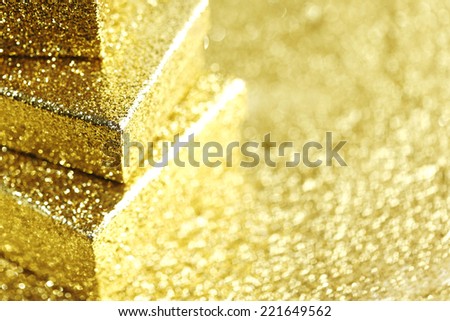 Stack of Gold decorative boxes with holiday gifts on abstract gold background