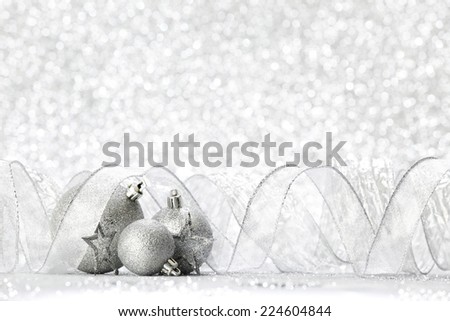 Silver christmas balls and stars on silver glitter background