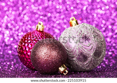 Beautiful purple christmas balls on abstract glitter background close-up