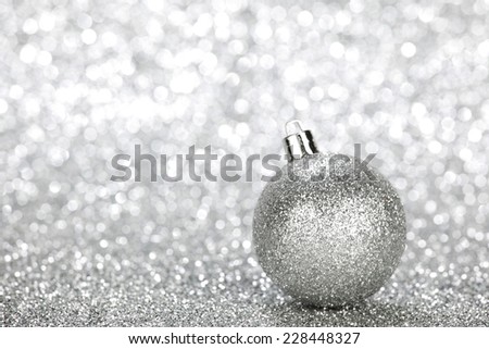 One chritmas ball on glitters with bokeh background