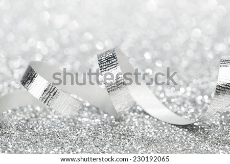 Shiny silver gift ribbon on bokeh background close-up