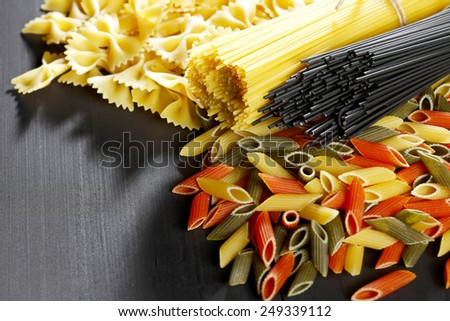 Variety of types and shapes of Italian pasta on black table